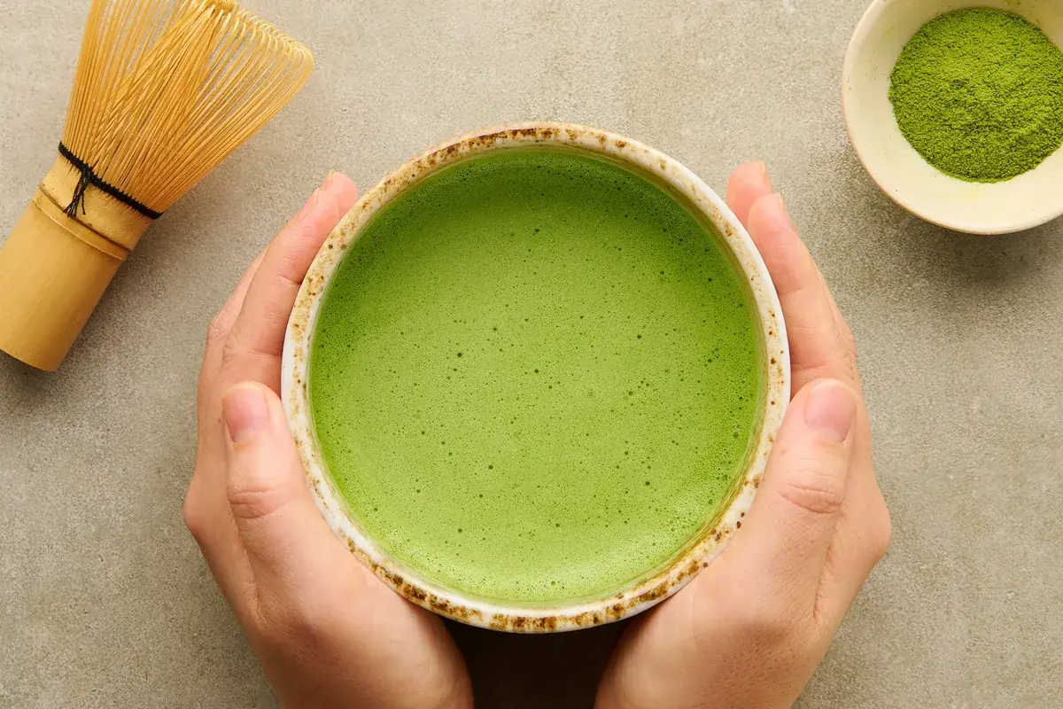 Prepared matcha bowl with bamboo whisk and matcha powder